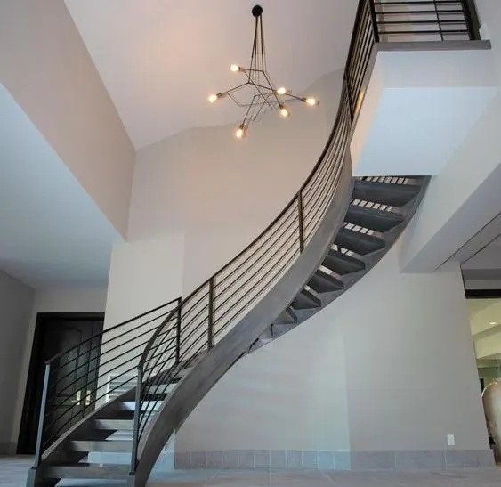 Cầu thang sắt trong nhà uốn lượn với lan can sắt thanh ngang