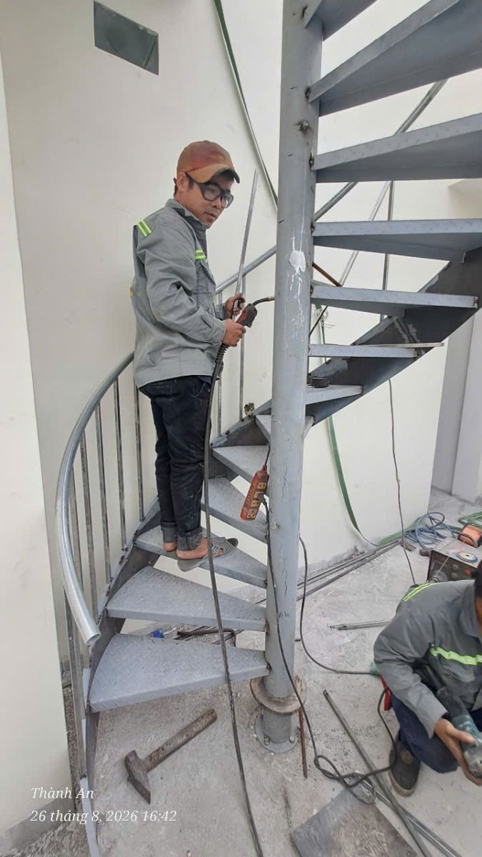 Thợ thi công tiến hành hàn CO2 chuyên dụng hoàn thiện các chi tiết cầu thang xoắn ốc